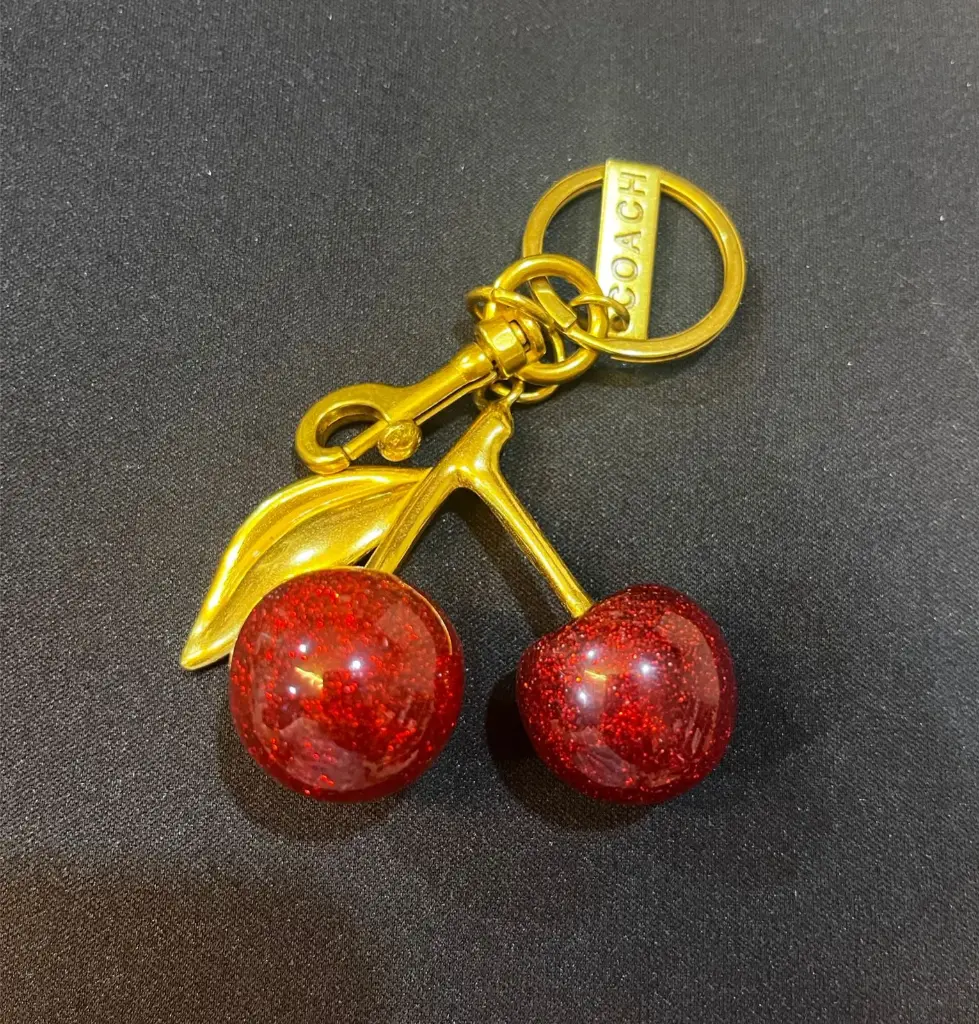 COACH Llavero Cerezas dorado